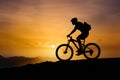 Mountain biker symbolizing triumph, overcoming challenges, sunset silhouette