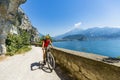 Mountain biking at sunrise woman over Lake Garda on path Sentiero della Ponale, Riva del Garda, Italy