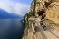 Mountain biking sunrise woman at sunrise over Lake Garda on path Sentiero della Ponale, Riva del Garda, Italy