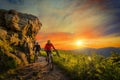 Mountain biking women and man riding on bikes at sunset mountain