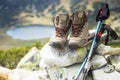 Mountain boots and trekking sticks on mountain peak Royalty Free Stock Photo