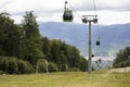 Mountain Cable car / gondola in the summer. Mountains in the background and cloudy sky