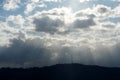 Mountain called Uetliberg on the horizon of Zurich. Sun rays are penetrating through clouds covering the sun creating irregular pa