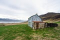 Mountain chain with snow on it. Blue abandoned farmhouse infront of it.