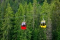 Mountain chairlift on the background of green pine forest Royalty Free Stock Photo