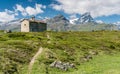 Mountain church in an idyllic mountain landscape in the summertime in the Alps with snow-capped peaks in the background