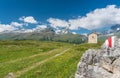 Mountain church in an idyllic mountain landscape in the summertime in the Alps with snow-capped peaks in the background and a hiki