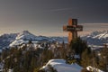 Mountain cliff Buchensteinwand at Wilder Kaiser with viewpoint and sightseeing spot Jakobskreuz during sunset in winter with snow