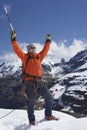 Mountain Climber With Arms Raised On Snowy Peak Royalty Free Stock Photo