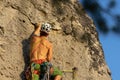 Mountain climber climbing the cliff using his climbing equipment