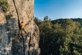 Mountain climber climbing the cliff using his climbing equipment