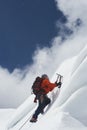 Mountain Climber Going Up Snowy Slope With Axes