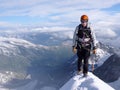 Mountain climber on a steep and narrow snow ridge leading to a high peak in the Swiss Alps Royalty Free Stock Photo