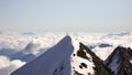 Mountain climber stands on an summit ridge with a great view behind Royalty Free Stock Photo