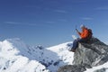 Mountain Climber Using Laptop And Walkie Talkie On Mountain Peak