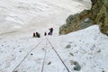 Mountain climbers with ropes on snow