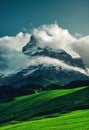 a mountain with a cloud in the sky above it and green grass below it and a blue sky with clouds Royalty Free Stock Photo