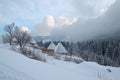 Mountain cottage in winter, pine forest, sky and clouds