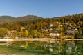 Mountain cottages and holiday homes on the shores of Lake Jasna in beautiful autumn colors forest in northern Slovenia