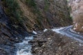 Mountain creek between rocks near the road Royalty Free Stock Photo