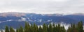 Mountain crests with clouds and fir tips