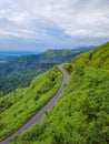 Mountain curvy tarmac road with hill range background and dramatic sky at morning Royalty Free Stock Photo