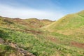 Mountain desert, plain field meadow hill with green grass and red soil Royalty Free Stock Photo