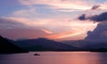 Mountain, dramatic sky, boat on sea at sunset Royalty Free Stock Photo