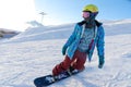 MOUNTAIN ELBRUS, RUSSIA - NOVEMBER 30, 2017: A snowboard girl wearing a sun mask and a scarf is riding down the alpine