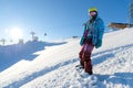 MOUNTAIN ELBRUS, RUSSIA - NOVEMBER 30, 2017: A snowboard girl wearing a sun mask and a scarf is stand on slope. The