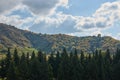 Mountain forest landscape with clouds, blue sky and freen trees Royalty Free Stock Photo