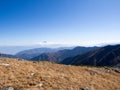 Mountain Fujiyama through cloud with blue sky at distance and dry meadow hill as foreground