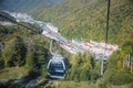 Mountain funicular through autumn forest on backdrop of Caucasus mountains to observation deck tops 2320 m. A clear