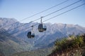 Mountain funicular through autumn forest on backdrop of Caucasus mountains to observation deck tops 2320 m. A clear