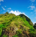 Mountain, green and natural landscape with blue sky, summer and calm clouds on peak at travel location. Nature, cliff Royalty Free Stock Photo