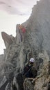 Mountain guide and client heading towards a high alpine summit on a foggy day