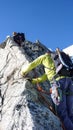 Mountain guide leading male client to the summit of a high alpine peak on a beautiful summer day