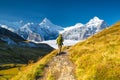 A mountain hiker with a backpack against the backdrop of a mountain panorama. Mountain hiking in the high mountains. Travel and ad