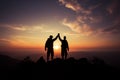 Mountain hikers celebrate, hands raised in silhouette, embodying teamwork\'s success Royalty Free Stock Photo