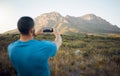 Mountain, hiking man and smartphone photography in nature, outdoors or countryside. Adventure, travel and man on 5g Royalty Free Stock Photo