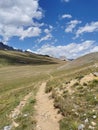 Mountain hiking trail on french alps during summer sourrounded by grazing lands Royalty Free Stock Photo