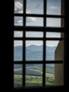 Mountain hills view from a barred castle window