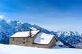 Mountain house partially submerged in snow