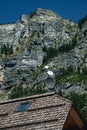 Mountain house roof with satellite dish antenna below the rocky Julian Alps mountains in summer Royalty Free Stock Photo