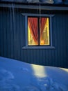 mountain hut and w indow light in the snow in the evening