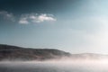 Mountain lake in foggy morning. Blue sky with clouds and fog over the water Royalty Free Stock Photo