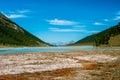 Mountain lake among the forested slopes. View of the valley.