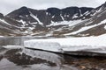 Mountain lake with glacier, snow melting is in Khibiny Massif at spring season. The Kola peninsula, Russia