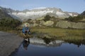 In a mountain lake the landscape is reflected. a hiker makes a break