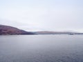 Mountain lake before misty sunset in Higland in Scotland. Snowy cone of mountain above mirroring water